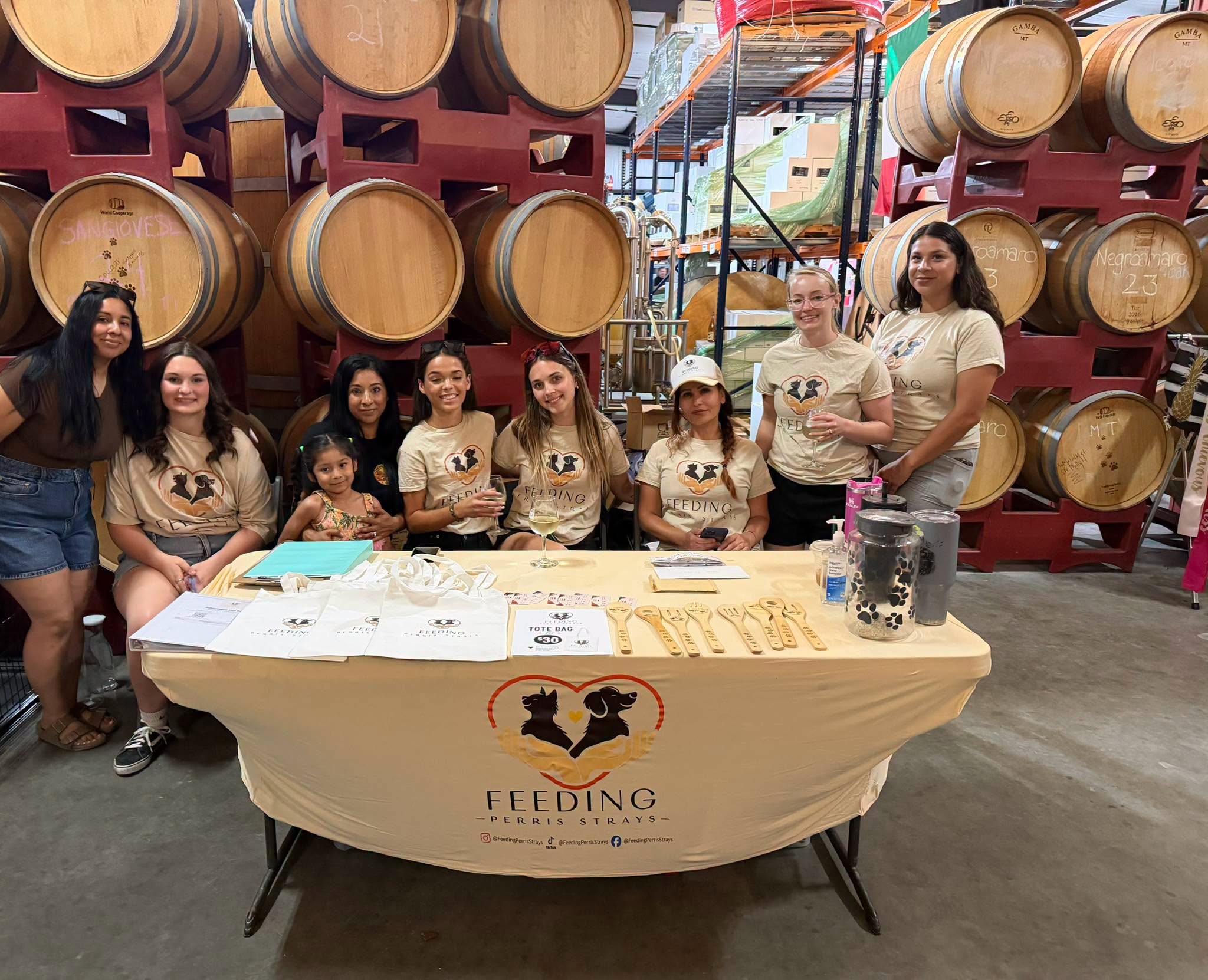 Feeding Perris Strays volunteers at a community table during a 2026 adoption event, from left to right: Alexis, Renee, Camilia, Sabrina, Isabelle, Jayice, Nasrin, Bailey, and Anissa, among others